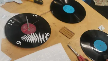 Als Wanduhren wiederverwendete Schallplatten auf dem Tisch.