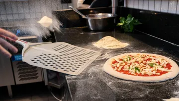 Mehl über die Pizza auf der Theke gestreut.