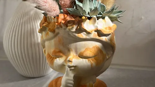 Decorative planter shaped like serene face.