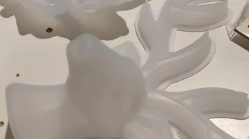 Frosted glass sculpture with leaf design on table.