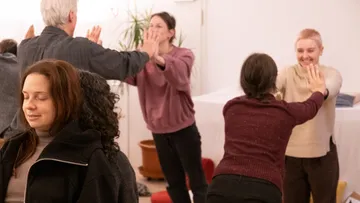 Personen, die an Gruppenmeditationsübungen teilnehmen.