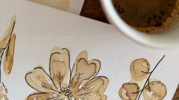 Coffee mug and floral painting on paper.