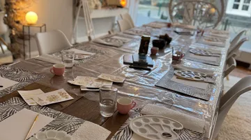 Art supplies on a long table, indoor setting.