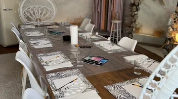 Art supplies on a long wooden table.