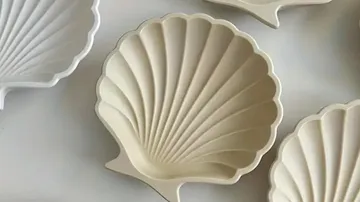 Muschelförmiges Keramikgeschirr auf weißer Oberfläche.