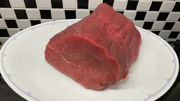 Rohes Rindersteak auf einem weißen Teller.