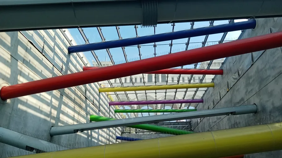 Colourful pipes hang diagonally in a modern room.