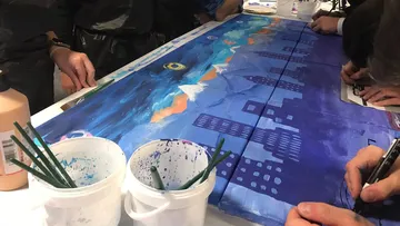 People painting a colorful mural together.