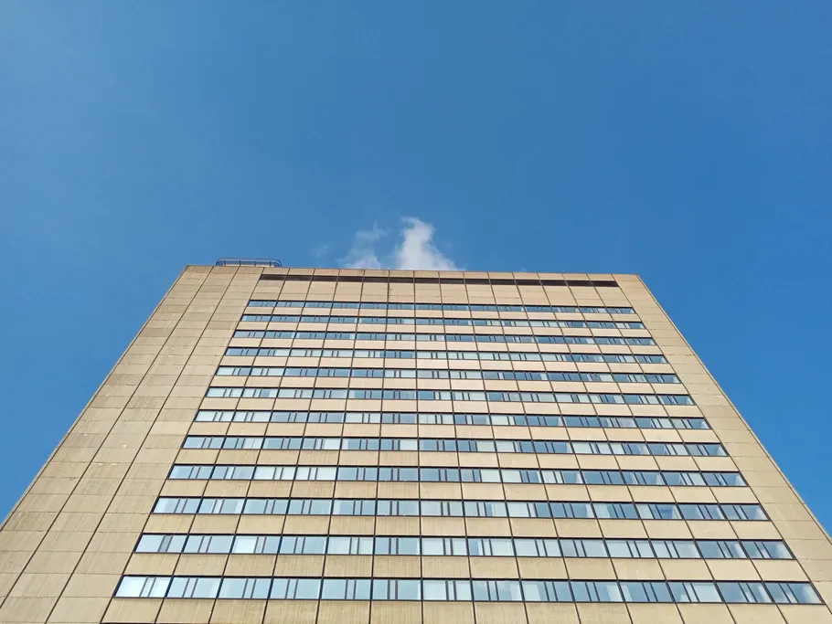Skyscraper with lots of windows under a blue sky.