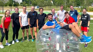 Gruppe von Menschen, die auf einem Sportplatz posieren.