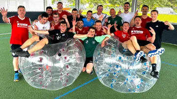Group of people posing with inflatable bubbles, outdoors.