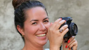 Lächelnde Frau mit einer Canon-Kamera.