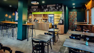 Cozy cafe interior with tables and counter.