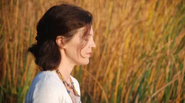 Woman standing in front of tall grass.