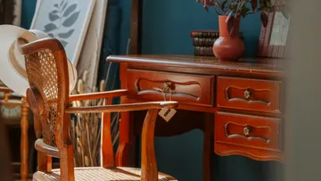 Wooden chair, desk, hat, and vase indoors