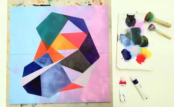 Geometrische Malerei mit Farbpalette auf dem Tisch.