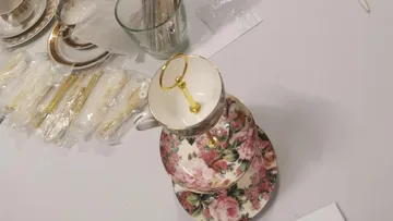 Floral teacup-tiered stand on table.