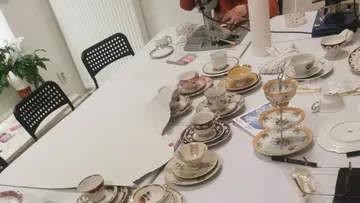 Teacups and saucers on a workshop table.