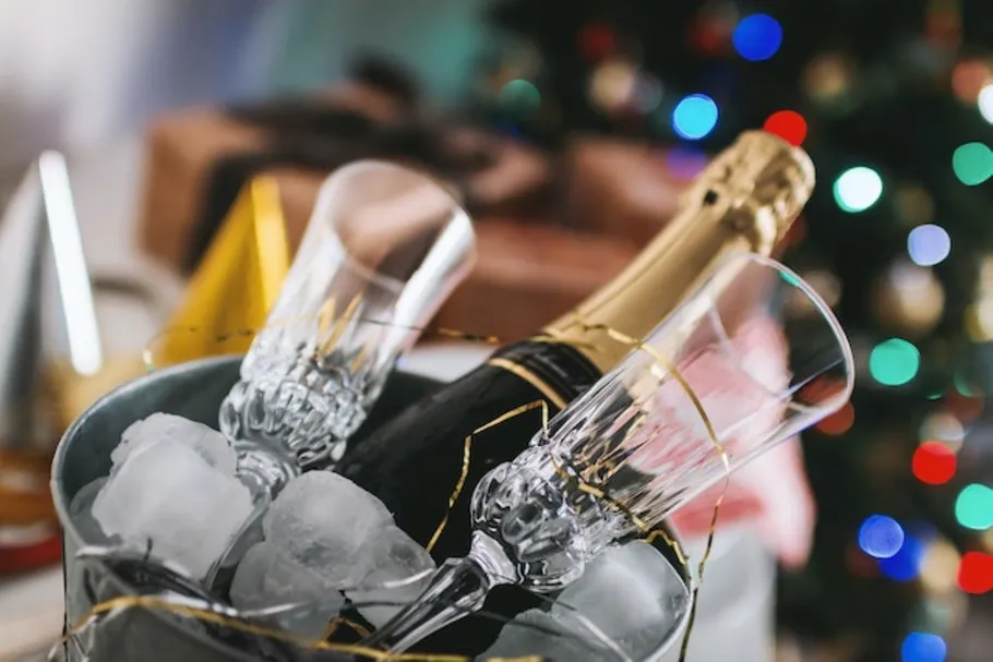 Champagne bottle and glasses in ice bucket.