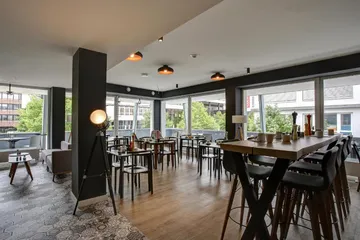 Modern cafe with wooden tables and high stools.