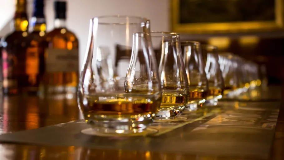 Row of whiskey glasses on a table.