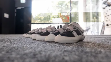 Reihe grauer Schuhe auf Teppichboden.