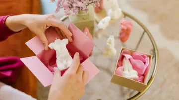 Box zum Öffnen der Hände mit einer kleinen Skulptur im Inneren.