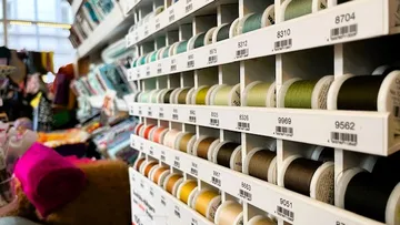 Spools of colored thread on shelves in store.
