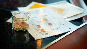 Glas mit Getreide neben der Brauanleitung.