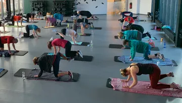 People exercising on mats in a gym.