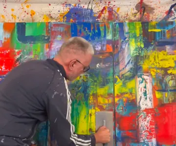 Person opening colorful abstract painting door.