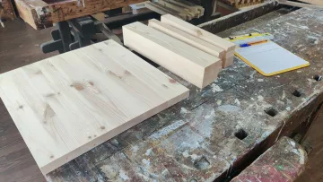Wooden planks and clipboard on workbench.