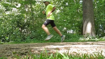 Man running on forest trail.