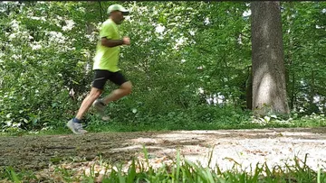 Runner-in-bright-clothes-jogging-in-forest