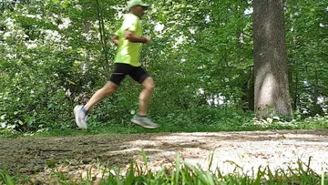 Man running on forest path.