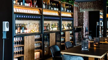 Wine dispensers and bottles in a modern bar.