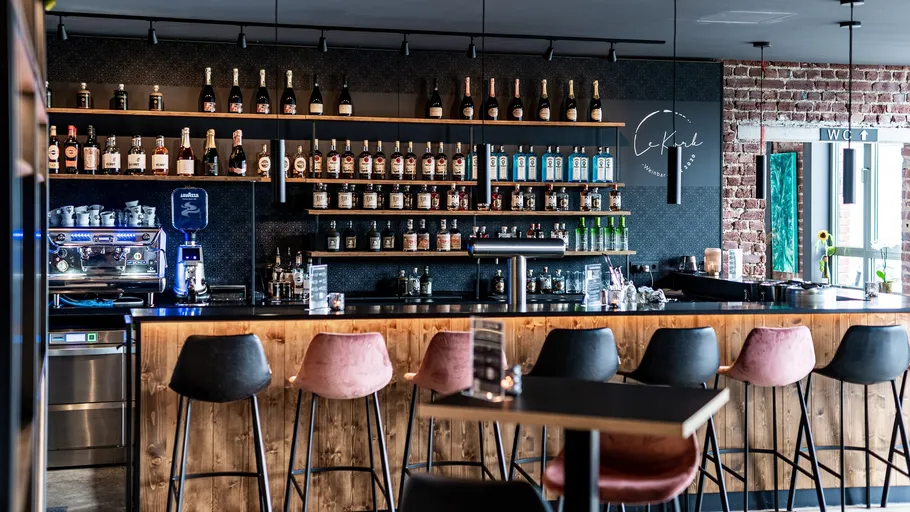 Chic bar with high stools and liquor shelves.