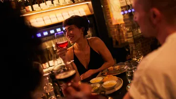 Leute, die Getränke und Essen in einer Bar genießen.