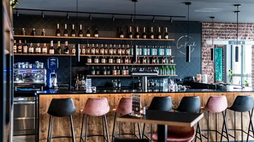 Moderne Bar mit Regalen voller Spirituosenflaschen.