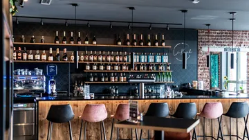 Stylish bar with bottles and stools.
