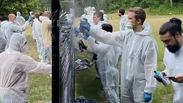 Gruppen-Sprühlackieren im Freien in Schutzanzügen.