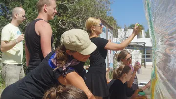 Die Leute sprühen im Freien Farbe auf Plastik.