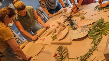 Leute, die Tonwalzen auf botanischen Abdrücken verwenden.