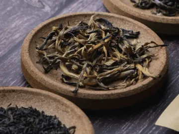 Tea leaves lie on a round, flat plate.