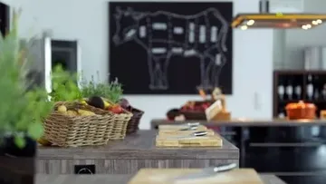 Küche mit Schneidebrettern und Kuhdiagramm an der Wand.