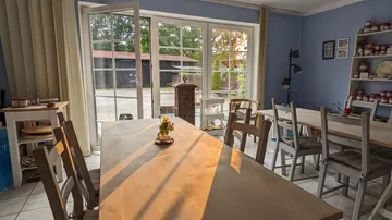 Sonniges Atelier mit Holztischen und Stühlen.