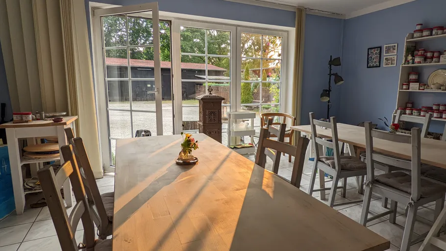Sunny dining room with wooden tables and chairs.