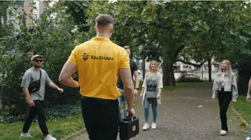 Person in yellow shirt leading group in park.
