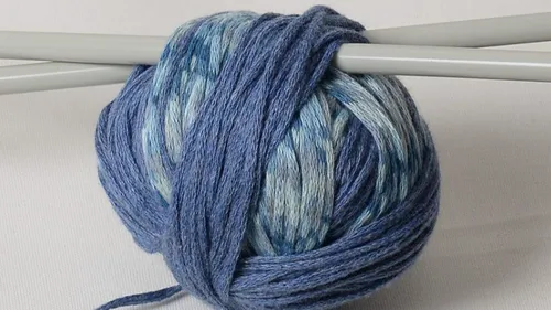 Blue yarn ball with knitting needles.