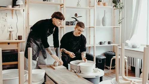 Two people making pottery in studio.